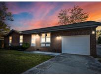 Charming brick home featuring a well-maintained lawn and an attached garage with an inviting sunset at 132 Heather Dr, Summerville, SC 29486