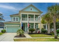 Charming two-story home featuring a double porch, aqua-colored siding, and well-maintained landscaping at 1543 Watoga Way, Mount Pleasant, SC 29466
