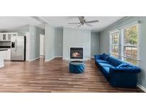 Bright living room features a fireplace, wood floors, and comfortable blue velvet seating at 158 Dean Dr, Summerville, SC 29483