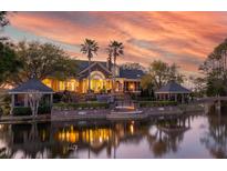 Stunning waterfront home at sunset, featuring a brick patio and lush landscaping at 1644 Omni Blvd, Mount Pleasant, SC 29466