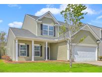 Charming two-story home with green siding, white trim, and a well-manicured front lawn at 189 Weeping Cypress Dr, Moncks Corner, SC 29461