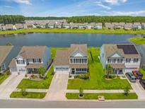 Stunning aerial view of homes lining a serene lake with lush green landscapes and community in the background at 260 Dunlin Dr, Summerville, SC 29486