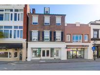 A charming brick building with white trim and black shutters offers an elegant and classic aesthetic at 348 King St # I, Charleston, SC 29401