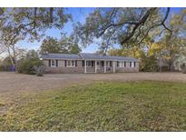 Charming single-story brick home with a well-manicured front yard, black shutters, and a welcoming front porch with swing at 434 Shannon Dr, Mount Pleasant, SC 29464