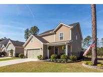 Inviting two-story home with a manicured lawn, attached garage, and a charming front porch, perfect for relaxing at 505 Kilarney Rd, Summerville, SC 29483