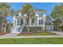 Charming two-story home with a welcoming front porch and well-manicured lawn and a bright blue front door at 1115 Barfield St, Charleston, SC 29492