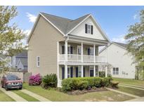Charming two-story home featuring a front porch, balcony, and lush landscaping at 112 Tin Can Aly, Summerville, SC 29483