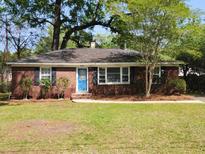 Charming one-story brick home with a well-manicured lawn and a bright blue front door at 141 Harvey Ave, Goose Creek, SC 29445