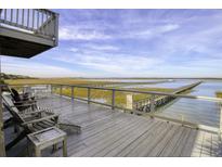 Enjoy the deck's scenic marsh views and the nearby boardwalk for tranquil outdoor relaxation and entertaining at 1504 Forrest Ave, Folly Beach, SC 29439
