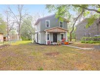 Charming two-story home featuring a quaint front porch, landscaped yard, and mature trees at 1617 Balsam St, Charleston, SC 29407