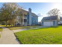 Beautiful two-story home with a well-maintained lawn and detached garage with a basketball hoop at 2107 Military Way, Charleston, SC 29414