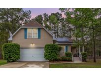 Charming home with a two-car garage, blue shutters, solar panels, and manicured landscaping at 234 Lipman St, Summerville, SC 29483