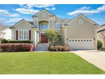 Beautiful two-story home with a manicured lawn, red front door, and attached two-car garage at 2616 Magnolia Woods Dr, Mount Pleasant, SC 29464