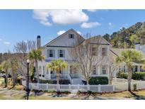 Charming white two-story home featuring a welcoming front porch and landscaped yard with a white picket fence at 2681 Park West Blvd, Mount Pleasant, SC 29466