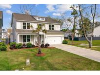 Charming two-story home featuring a manicured front lawn, covered porch, and attached two-car garage at 2830 Backman St, Mount Pleasant, SC 29466