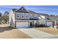 Two-story home featuring a two-car garage and a well-manicured lawn and landscaping at 307 Blue Oak Dr, Moncks Corner, SC 29461
