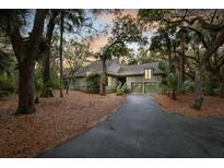 Charming home featuring a two-car garage and lush landscaping with mature trees, creating a private and inviting atmosphere at 3110 Up Da Creek Ct, Seabrook Island, SC 29455