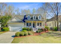 Charming yellow home featuring a quaint front porch with decorative flower boxes and lush landscaping at 3447 Toomer Kiln Cir, Mount Pleasant, SC 29466