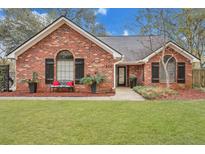 Charming brick home featuring a well-manicured front yard, front bench and complemented by lush landscaping at 462 Mount Royall Dr, Mount Pleasant, SC 29464