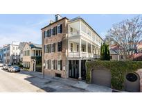 Charming traditional-style home with a double balcony, shuttered windows, and an ivy-covered garage at 61 Tradd St, Charleston, SC 29401