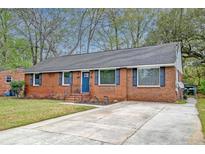 Charming brick home featuring a well-maintained yard, blue shutters, and a concrete driveway at 746 Cartwright Dr, Charleston, SC 29414