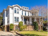 Stunning two-story home with white siding, a columned porch, manicured lawn, and brick accents at 772 Post Oak Dr, Mount Pleasant, SC 29464