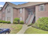 Inviting two-story condo with charming curb appeal, front stairs, and well-maintained landscaping at 7940 Parklane Ct # F, North Charleston, SC 29418
