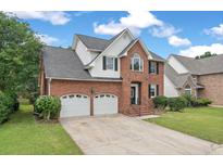 Charming brick two-story home with a two-car garage and well-manicured lawn at 105 N Gateshead Xing Xing, Goose Creek, SC 29445