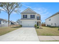 Charming two-story home with a gray exterior, manicured lawn and a concrete driveway leading to a two-car garage at 1132 Mossy Rock Dr, Summerville, SC 29485