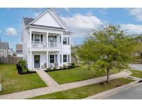Charming two-story home featuring a welcoming front porch and well-manicured lawn at 1586 Innkeeper Ln, Johns Island, SC 29455