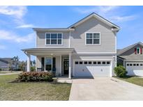 Charming two-story home with a well-manicured lawn, covered porch, and two car garage at 271 Palmetto Walk Dr, Summerville, SC 29486