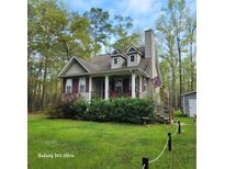 Charming home featuring a cozy front porch, dormer windows, and mature landscaping at 2729 Barracada Rd, Walterboro, SC 29488