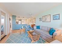 Coastal living room featuring a light blue rug, comfortable seating, and a peek into the adjacent kitchen at 3701 Docksite Rd # 108, Edisto Beach, SC 29438