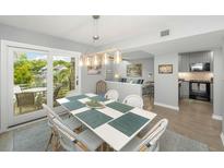 Bright dining room with a modern table, seating for six, and sliding door access to an outdoor space with a view at 4364 Sea Forest Dr, Kiawah Island, SC 29455