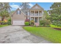 Charming two-story home featuring a spacious front yard, two-car garage, and a welcoming double-decker porch at 5411 Nesting Pl, North Charleston, SC 29420
