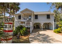 Charming elevated home with mature trees, a covered parking area, and beautiful landscaping at 864 Club Cottage Rd, Edisto Beach, SC 29438