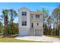 Stunning three-story home with dual garages, a light grey exterior, and double balconies at 1615 Macoma Rd, Mount Pleasant, SC 29466