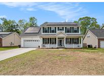 Charming two-story home featuring a welcoming front porch and solar panels on the roof at 176 Hainsworth Dr, North Charleston, SC 29418