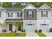 Charming townhome featuring attached garage, manicured lawn, and modern design elements at 178 Buchanan Cir, Goose Creek, SC 29445