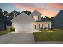 Charming two-story home with a well-manicured lawn and attached two-car garage at sunset at 206 Alpine Rd, Summerville, SC 29485