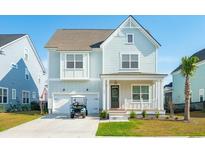 Charming light blue two-story home with a front porch, garage, and driveway with golf cart at 2951 Clearwater Dr, Mount Pleasant, SC 29466
