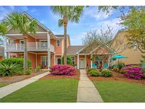 Inviting two-story home with lush landscaping, vibrant flowers, and a charming walkway leading to the front door at 2952 Sweetleaf Ln, Johns Island, SC 29455