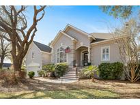 Charming home with a stucco facade, manicured landscaping, and an American flag at 3075 Maritime Forest Dr, Johns Island, SC 29455
