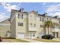 A charming townhome featuring a two car garage, dormer windows, and a well maintained yard at 4512 Great Oak Dr, North Charleston, SC 29418