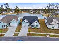 Charming light blue home featuring a three car garage and a tranquil lake view at 552 Marsh Cv Cir, Summerville, SC 29486