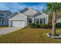 Charming single-Gathering home featuring a well-manicured front lawn and attached two-car garage at 9723 Flooded Field Dr, Ladson, SC 29456