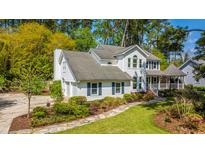 Charming two-story home with white siding, lush landscaping, and a welcoming front porch at 116 Delaney Cir, Summerville, SC 29485