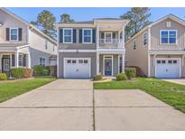 Charming two-story home featuring a balcony, one-car garage, and manicured lawn at 2001 Poplar Grove Pl, Summerville, SC 29483