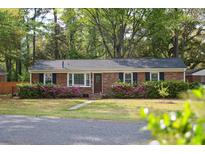 Charming brick home with a well-manicured lawn and vibrant flower bushes at 2158 Till Rd, Charleston, SC 29414