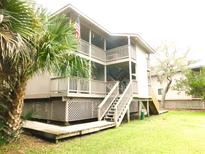 Charming multi-story house with open balconies, wooden stairs, and a well-maintained lawn at 229 Linkside Villas # 1/3 Share, Edisto Beach, SC 29438